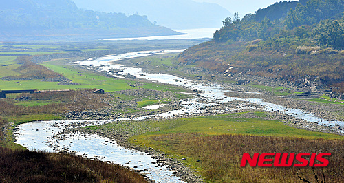 [보령=뉴시스] 지난 2015년 가뭄으로 저수율이 현저히 낮아진 충남 보령댐 상류 지역에 수몰된 집터와 도로 사이로 실개천이 흐르는 모습. (사진=뉴시스 DB). photo@newsis.com