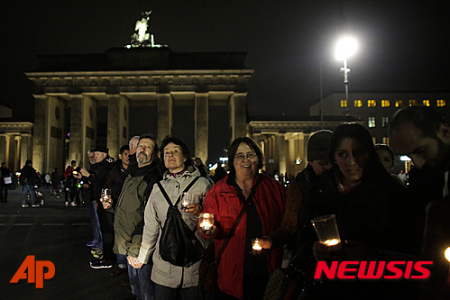 【베를린=AP/뉴시스】17일(현지시간) 독일 베를린에서 시민들이 '난민 환영- 불을 밝혀라'라는 모토의 촛불 시위를 벌이고 있다. 이날 반난민 정서가 악화하고 있는 독일 쾰른에서 여성 시장 후보가 극우주의자로 추정되는 남성으로부터 피습을 당해 중태에 빠졌다. 2015.10.18