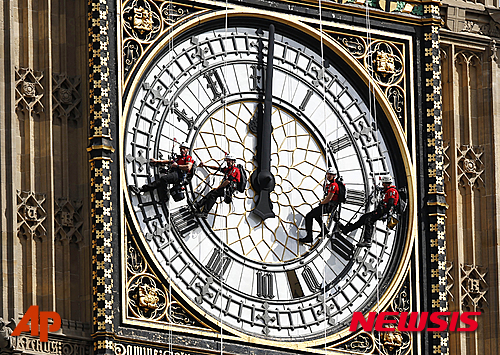 【런던=AP/뉴시스】지난 2014년 8월18일 자료사진으로 인부들이 영국 런던 국회의사당에 있는 시계탑인 빅벤의 외관을 자일을 타고 내려오면서 청소하고 있다. 영국에서 유명 일간들이 18일(현지시간) 영국 의회 재정위원회가 4000만 파운드(약 693억 원)를 들여 올 여름 잘못된 시간에 종을 울린 빅벤을 수리하기로 했다고 보도했다. 2015.10.19&nbsp; 