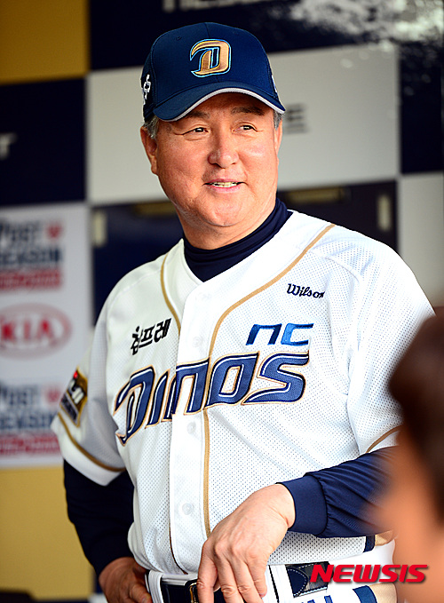 【창원=뉴시스】박영태 기자 = 19일 오후 경남 창원시 마산구장에서 열린 ‘2015 타이어뱅크 KBO리그’ 플레이오프 NC 다이노스와 두산 베어스의 2차전 경기 전 NC 김경문 감독이 취재진과 이야기를 나누며 훈련하는 선수들을 바라보고 있다. 2015.10.19. since1999@newsis.com