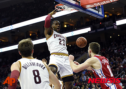 Cleveland Cavaliers' LeBron James (23) dunks the ball over Philadelphia 76ers' Nik Stauskas during the second half of an NBA basketball game, Monday, Nov. 2, 2015, in Philadelphia. The Cavaliers won 107-100. (AP Photo/Michael Perez)