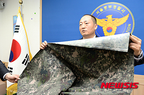 【서울=뉴시스】홍찬선 기자 = 5일 오전 서울 중구 중부경찰서에서 이상엽 수사과장이 신형전투복 원단을 불법제조 및 유통한 피의자 7명 검거 브리핑을 하며 가짜 전투복 원단을 들고 있다. 2015.11.05.&nbsp; mania@newsis.com
