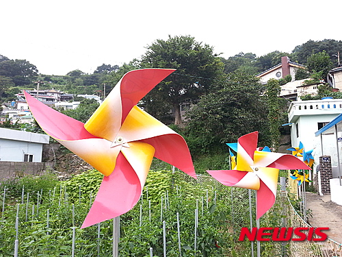 【여수=뉴시스】김석훈 기자 = 11일 전남 여수시 동문동 당산마을에 바람개비가 일제히 설치되면서 예쁜 바람개비 마을로 변모 했다. 삼남석유화학㈜(공장장 채승우)은 지역사회공헌사업의 일환으로 해상케이블카가 지나는 여수시 하멜공원 주변 당산마을을 '바람개비마을'로 조성했다고 밝혔다. 2015.11.11. (사진=경제실천연합여수지구 제공)&nbsp;&nbsp; kim@newsis.com