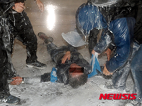 【서울=뉴시스】조성봉 기자 = 14일 저녁 서울 광화문에서 열린 민중총궐기대회에서 전남 보성농민회 백 모씨(70)씨가 차벽에 밧줄을 걸고 당기던 중 경찰의 물대포를 맞고 쓰러져 있다.&nbsp; 코피를 흘리며 쓰러진 농민은 뇌진탕 증세를 보이며, 아스팔트에 누워있다가 구급차로 서울대학교병원 응급실로 호송됐으나 위독한것으로 알려졌다. 2015.11.14. suncho21@newsis.com