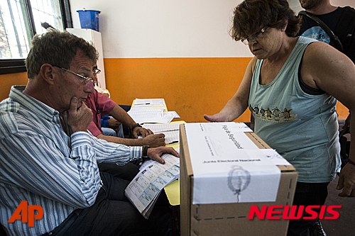 【부에노스아이레스=AP/뉴시스】아르헨티나 여성이 22일(현지시간:) 부에노스아이레스에 있는 한 투표소에서 투표용지를 받고 있다. 아르헨티나 대통령선거 결선 투표가 이날 오전 전국 1만3800개 투표소에서 일제히 시작됐다. 2015.11.23 