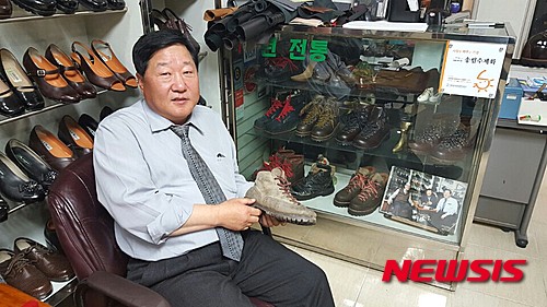 【서울=뉴시스】유자비 기자 = 25일 서울 중구 을지로 3가에 있는 송림수제화에서 임명형 사장이 김영삼 전 대통령이 수선을 맡겼던등선화와 같은 디자인 제품을 손에 들고 있다.