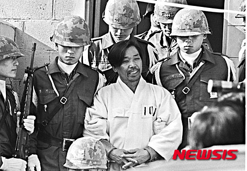 【서울=뉴시스】박정희 대통령 시해사건 관련자 김재규(전 중앙정보부장) 피고인이 육군본부 계엄 보통군법회의(재판장 김영선 중장)에서 선고공판을 받기 위해 포승에 묶여 걸어오며 웃고 있다. 이날 김재규, 김계원, 박선호, 박흥주, 이기주, 유성옥, 김태원 등 7명은 내란목적살인죄가 적용돼 사형을 선고 받았다. <1979년 12월20일, 권주훈> 