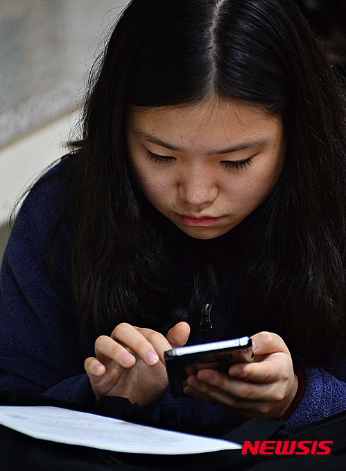 【청주=뉴시스】인진연 기자 = 2016학년도 수능시험 성적표 배부 날인 2일 오전 충북 청주시 일신여자고등학교 교실에서 한 학생이 스마트폰으로 성적표를 확인하고 있다. 2015.12.02 inphoto@newsis.com