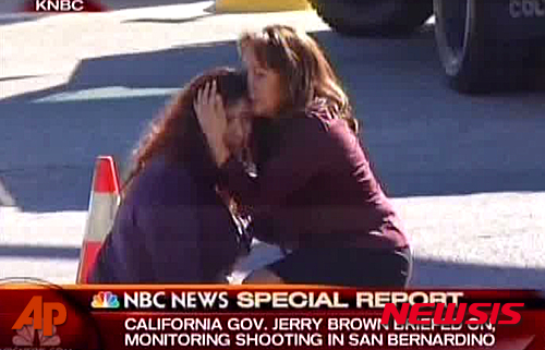 【샌버너디노=AP/뉴시스】미국 캘리포니아주 샌버너디노 사회복지센터에서 2일(현지시간) 총기난사 사건이 발생해 최소 14명이 사망했다. 한 여성이 센터 앞에서 주저 앉아 울부짖자 다른 여성이 달래고 있다. 2015.12.03