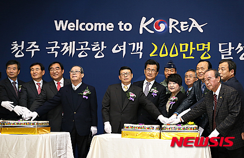【청주=뉴시스】인진연 기자 = 충북 청주국제공항이 처음으로 연간 여객 200만 명을 넘어선 10일 오후 공항 1층 대합실에서 열린 행사에서 참석자들이 기념떡을 자른 뒤 기념촬영 하고 있다. 2015.12.10&nbsp; inphoto@newsis.com
