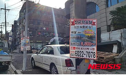 【제주=뉴시스】김용덕 기자 = 제주시는 최근 제2공항 관련 부동산·건물 분양에 따른 불법 현수막 500장을 단속해 철거 및 과태료를 부과했다고 15일 밝혔다. 사진은 제주시 연동 지역 전봇대 등에 부착된 불법 부동산 분양 현수막. 2015.12.15. (사진 = 제주시 제공)&nbsp; kydjt6309@newsis.com