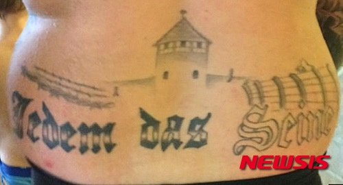 【서울=뉴시스】독일에서 나치 강제수용소인 아우슈비츠를 표현한 타투(문신)를 새긴 남성이 증오 조장 혐의로 기소됐다고 16일(현지시간) BBC가 전했다. 이 타투는 독일 부헨발트 나치 강제수용소 입구에 써붙인 ‘Jedem das Seine’라는 구호를 포함하고 있다. (사진: BBC 보도 캡처) 2015.12.17.