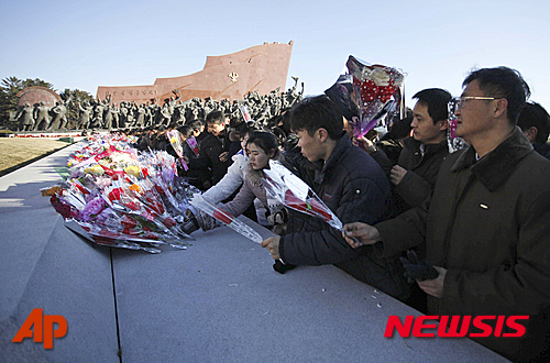 【평양=AP/뉴시스】북한 평양 시민들이 17일 김정일 국방위원장 사망 4주기를 맞아 만수대 언덕의 김정일,김일성 동상 앞에 헌화하고 있다. 2015.12.17