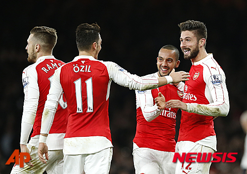 Arsenal's Theo Walcott, second right, is congratulated by teammates after scoring the opening goal of the game during the English Premier League soccer match between Arsenal and Manchester City at the Emirates stadium in London, Monday, Dec. 21, 2015. (AP Photo/Alastair Grant)