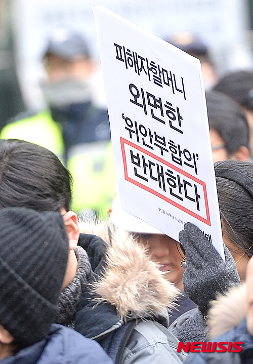 [서울=뉴시스]장세영 기자 = 지난 2015년 12월30일 오후 서울 종로구 중학동 일본대사관 앞에서 열린 2015년 돌아가신 일본군 위안부 피해자를 위한 추모회 및 제1211차 일본군 위안부 문제해결을 위한 정기 수요집회에서 한 시민이 위안부 한일협정을 반대하는 문구를 들고 있다.&nbsp; 2015.12.30. photothink@newsis.com