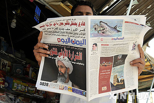 【사나=신화/뉴시스】예멘 수도 사나에서 3일(현지시간) 한 남성이 사우디 아라비아 시아파 지도자 님르 바크르 알-님르의 처형 뉴스를 1면 톱기사로 다룬 일간지를 읽고 있다. 2016.01.04