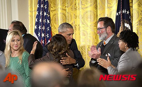 【워싱턴=AP/뉴시스】버락 오바마 미국 대통령이 5일(현지시간) 워싱턴 백악관 이스트룸에서 총기규제 강화 행정명령을 발표한 뒤 총기 사건으로 아들을 잃은 뒤 '미국의 총기 규제를 위한 행동을 요구하는 엄마들을 위한 전국 대변인'회의 루시 맥배스를 안아주고 있다. 2016.01.05