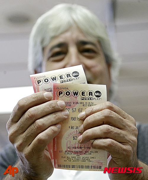【하이알리어=AP/뉴시스】미국 플로리다주 하이알리어의 한 식품점에서 6일(현지시간) 한 여성이 구매한 파워볼 티켓을 들어보이고 있다. 이날 추첨에서 당첨자가 나오지 않으면서 오는 9일 추점까지 당첨금이 6억 7500만 달러(약 8101억 원)에 달할 것으로 예상되고 있다. 복권국 관계자는 현재 당첨금 액수가 미국 복권 사상 최고액이라고 밝혔다.2016.01.07