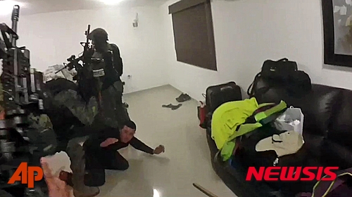 【 멕시코대통령실 ·AP/뉴시스】멕시코 해병대원들이 지난 8일 로스 모치스에 있는 '마약왕' 구스만의 은둔지에서 체포작전을 펼치는 중 구스만의 측근으로 보이는 남성을 제압하고 있는 모습. 멕시코 대통령실은 해병대원들이 구스만 체포 작전 중 촬영한 동영상을 11일(현지시간) 공개했다. 2016.01.12 