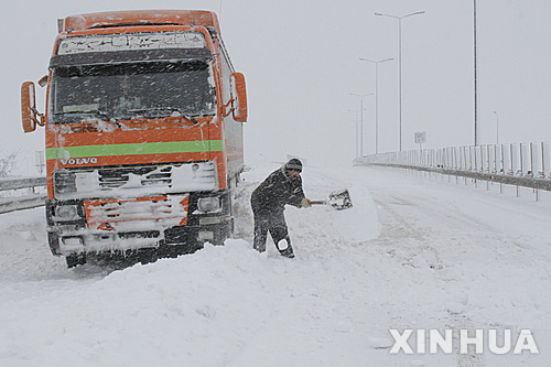 【 부카레스트=신화/뉴시스】루마니아 부카레스트에서 17일(현지시간) 트럭을 운전하던 남성이 도로 한복판에서 눈을 치우고 있다. 2016.01.18&nbsp; 