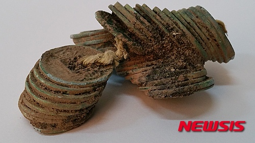 【서울=뉴시스】신진아 기자 = 광주 복룡동 유적 토광묘(웅무덤)에서 중국 신나라 화폐(화천) 꾸러기가 출토됐다. 화천이 무덤에서 꾸러미로 확인된 우리나라 최초 사례다.&nbsp;&nbsp; 문화재청의 허가를 받아 재단법인 동북아지석묘연구소가 광주 송정1교-나주시계의 도로확장공사구간 ‘광주 복룡동 유적’ 발굴조사를 했다. 그 결과 중국 신나라(新 8~23년) 화폐인 ‘화천(貨泉)’이 우리나라 최초로 무덤에서 꾸러미로 출토됐다.&nbsp; 기원후 14년에 처음으로 주조된 화천은 후한 광무제가 ‘오수전(五銖錢)’으로 화폐를 통합한 기원후 40년까지 통용된 화폐다. 정확한 주조연대를 알 수 있고 통용 시기가 한정돼 유적의 연대를 추정할 수 있는 중요한 자료다.&nbsp; 이번 조사에서는 청동기 시대 주거지와 초기철기 시대 토광묘, 수혈유구 등 총 95기의 유구가 확인됐다. 화천이 출토된 1호 토광묘는 길이 210㎝, 너비 82㎝, 잔존 깊이 10㎝의 장방형(긴 네모꼴) 평면 형태이다.&nbsp; 화천 꾸러미는 한쪽에 치우쳐 단경호(短頸壺; 짧은목항아리) 1점, 청색 유리옥 78점과 함께 발견됐다. 대부분의 화천은 지름이 2.2~2.3㎝이지만 2.6㎝인 다른 종류의 화폐도 있다.&nbsp; 화천이 무덤에서 꾸러미(50여 점)로 출토된 사례는 우리나라에서는 이번이 처음이다. 기존까지 우리나라에서 발견된 화천은 총 19점으로, 주로 조개더미 등 생활 관련 유적에서 소량으로만 확인됐다.&nbsp; 화천 출토 유적을 살펴보면 제주 산지항 11점, 제주 종달리 조개더미 1점, 제주 금성리 조개더미 2점, 김해 회현리 조개더미 1점, 해남 군곡리 조개더미 1점, 나주 복암리 랑동 유물포함층(저습지 추정) 2점, 신안 해저침몰선 1점 등이다.&nbsp; 중국 신나라 화폐인 화천은 영산강 유역과 남해안 지역, 제주 등 한정된 지역에서 출토되고 있다는 점에서, 당시 중국과 직접 교역을 했던 정치집단이 서남부 지역에 형성됐다고 볼 수 있다. 초기철기 시대의 이러한 거점지역은 남해안과 영산강의 해상 교역로를 따라 해남 군곡리, 나주 복암리, 광주 신창동·복룡동 일대에 형성됐을 것으로 추정된다.&nbsp; 한편 1호 토광묘에서 남서쪽으로 25m 정도 떨어진 2호 토광묘에서는 초기 철기 시대 경질무문장란형(硬質無文長卵形) 토기 1점, 점토띠토기 1점, 완형(盌形; 사발 모양)토기 1점, 쇠낫 1점이 확인됐다. 2호 토광묘의 평면형태도 길이 204㎝, 너비 87㎝, 깊이 22㎝ 정도의 장방형이다.&nbsp; 한편 광주 복룡동 유적 발굴조사는 29일까지 진행될 예정이다.&nbsp; jashin@newsis.com