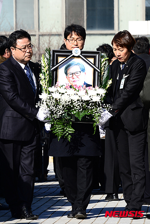 【서울=뉴시스】이영환 기자 = 18일 오후 서울 구로구 성공회대 대학성당에서 엄수된 고 신영복 석좌교수 영결식에서 헌화하며 애도하는 추모객들 사이로 운구행렬이 지나고 있다. 2016.01.18.&nbsp; 20hwan@newsis.com
