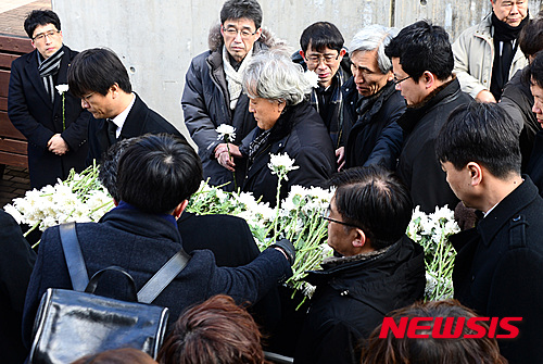 【서울=뉴시스】이영환 기자 = 18일 오후 서울 구로구 성공회대 대학성당에서 엄수된 고 신영복 석좌교수 영결식에서 헌화하며 애도하는 추모객들 사이로 운구행렬이 지나고 있다. 2016.01.18.&nbsp; 20hwan@newsis.com