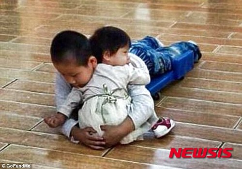 【서울=뉴시스】선천성 척추피열로 태어난지 3개월 만에 부모에게 버림 받은 중국인 소년 자자(9)가 오랜 기다림 끝에 최근 미국인 윌슨 부부에게 입양됐다. 자자는 척추 수술이 잘못돼 현재 하반신 마비 상태이지만, 윌슨 부부는 미국에서 자자가 최선의 치료를 받게 할 예정이다. 자자는 고아원에서 맏형으로, 어린 동생들을 돌보며 살아왔다. 사진은 자자(오른쪽)가 고아원 동생을 보살피고 있는 모습이다. (사진출처: 데일리메일) 2016.01.23.