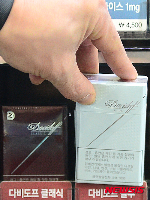 【서울=뉴시스】김동민 기자 = 담배업계에 따르면 KT&G는 25일부터 다비도프 시리즈 클래식과 블루 2개 제품과 람보르기니 시리즈 토니노 람보르기니, 아이스볼트GT, 구스토 등 총 5개 제품 가격을 4700원에서 4500원으로 200원 인하한다. 사진은 이날 오후 서울 중구 한 편의점에서 직원이 200원 인하되는 담배를 꺼내고 있다. 2016.01.25.&nbsp;&nbsp; life@newsis.com 