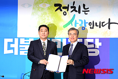 【서울=뉴시스】조수정 기자 = 문재인 더불어민주당 대표가 26일 오후 서울 여의도 국회에서 김병기 전 국가정보원 인사처장 입당 기자회견에서 입당 원서를 받고 있다. 2016.01.26.&nbsp; chocrystal@newsis.com