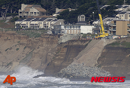【퍼시피카=AP/뉴시스】미국 캘리포니아주 퍼시피카의 해변가 절벽 끝에 27일(현지시간) 다세대 주택들이 아슬아슬하게 서있다. 엘니뇨 현상으로 인해 발생한 겨울폭풍 때문에 파도가 덮치면서 해변지대가 쓸려 나가버렸다. 당국은 안전을 위해 거주민 전원을 강제 대피시켰다. 2016.01.28