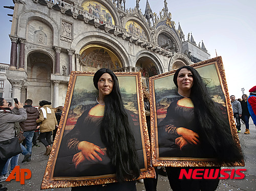 【베네치아=AP/뉴시스】이탈리아 베네치아 산마르코 광장에서 지난달 31일(현지시간) 카니발 참가자 2명이 레오나르다 다빈치의 '모나리자'그림 뒤에서 얼굴과 머리카락만 내밀고 포즈를 취하고 있다. 2016.02.01&nbsp;&nbsp; 