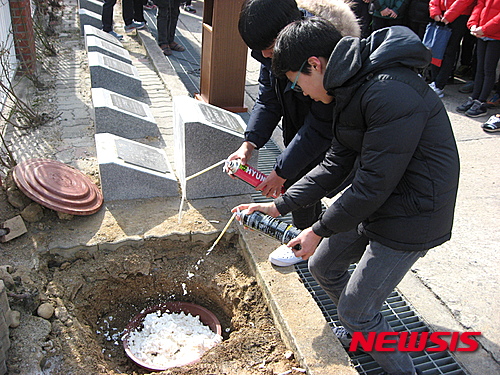 【충주=뉴시스】강신욱 기자 = 25일 충북 충주시 칠금초등학교 졸업생들이 20년 뒤 개천절에 열어볼 타임캡슐에 추억을 담은 물건들을 담은 뒤 우레탄 폼으로 밀봉하고 있다. 2016.02.05 (사진=칠금초등학교 제공)&nbsp;&nbsp; photo@newsis.com 