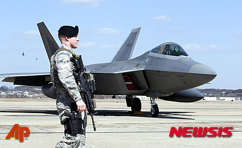 【평택=AP/뉴시스】경기도 평택 오산 미군기지에서 17일 오전 미 공군 병사가 세계 최강의 전투기로 평가되는 F-22 스텔스 전투기 옆에 서있다. 2016.02.17 