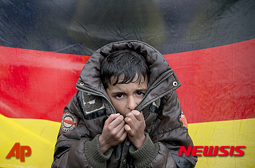 【이도메니=AP/뉴시스】그리스 이도메니에서 9일(현지시간) 한 소년이 추위에 떨고 있다. 뒤에 걸려있는 것은 독일 국기로, 난민 대다수는 마케도니아로 넘어가 발칸지역을 통과해 독일로 가기를 원하고 있다. 2016.03.10