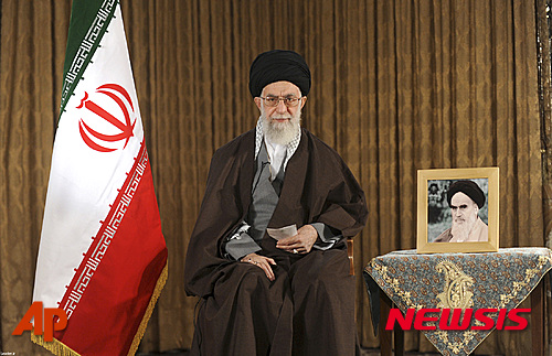 【AP/뉴시스】이란력(曆)으로 새해를 맞은 20일(현지시간) 아야톨라 세예드 알리 하메네이 이란 최고지도자가 새해 인사를 전하고 있다. 하메네이 최고지도자는 대국민 연설을 통해 국내 생산과 일자리 창출, 경기 회복 등을 강조하고 경제 성장을 염원했다. 하메네이 최고지도자 오른쪽에는 이란 이슬람혁명을 이끈 아야톨라 루홀라 호메이니의 사진이 놓여 있다. (사진 출처 = 이란 최고지도자 사무실 공식 웹사이트) 2016.03.20.