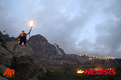 【아크레=AP/뉴시스】20일(현지시간) 이라크 아크레에서 한 쿠르드족 남성이 새해 첫 날인 노루즈 축제를 축하하며 횃불을 들고 서있다. 2016.03.21 