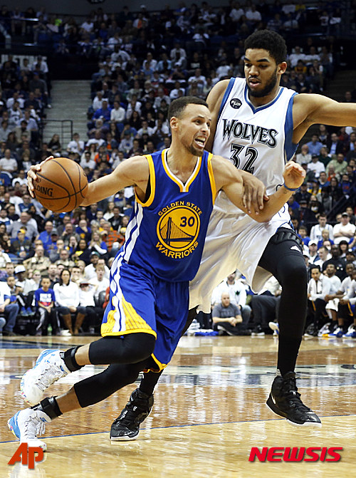 Minnesota Timberwolves? Karl-Anthony Towns, right, grabs onto Golden State Warriors? Stephen Curry as he drives in the second half of an NBA basketball game Monday, March 21, 2016, in Minneapolis. The Warriors won 109-104. (AP Photo/Jim Mone)