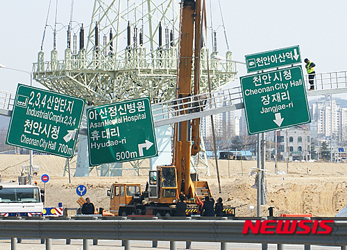 【아산=뉴시스】이종익 기자 = 30일 오전 충남 아산에서 천안 방향의 국도21호선 장재지하차도 입구에서 도로표지판이 도로로 주저앉아 이날 오후 경찰과 아산시가 천안방면 4차선의 차량 통행을 전면 통제하고 크레인 등을 동원해 보수작업을 진행하고 있다. 2016.03.30. 007news@newsis.com