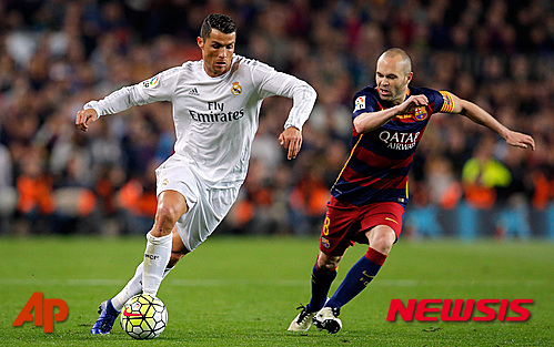 Real Madrid's Cristiano Ronaldo, left, drives the ball past Barcelona's Andres Iniesta during a Spanish La Liga soccer match between Barcelona and Real Madrid, dubbed 'el clasico', at the Camp Nou stadium in Barcelona, Spain, Saturday, April 2, 2016. (AP Photo/Manu Fernandez)