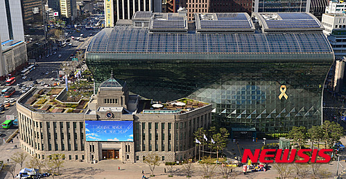 【서울=뉴시스】김선웅 기자 = 세월호 참사 2주기를 10여 일 앞둔 4일 오후 서울 중구 서울시청 외벽에 세월호 참사 희생자를 추모하는 노란 리본이 설치되어 있다. 리본에는 참사 희생자 304명의 이름과 실종자 9명의 이름이 적혀있으며 서울시는 이달 말까지 리본을 달 예정이다. 2016.04.04. mangusta@newsis.com