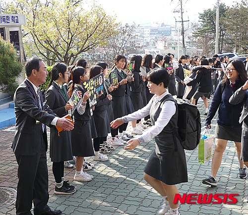 【청주=뉴시스】연종영 기자 = 11일 오전 청주 충북여고 현관 앞에서 김용범 교장(왼쪽)에게 등교하는 학생이 안기려 하고 있다. 이 학교 교사들과 청소년단체 소속 학생들은 지난해 9월부터 매일 아침 등굣길에 학생들을 격려하는 캠페인을 벌이고 있다. 2016.04.11.(사진=충북여고 제공) jyy@newsis.com