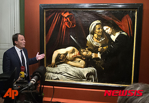 【파리=AP/뉴시스】프랑스 미술품 경매 전문가 마르크 라바르브가 12일(현지시간) 파리에서 최근 툴루즈 공동주택 다락에서 발견된 유화 그림을 공개하고 있다. 전문가들은 이 그림이 16세기 이탈리아 거장 화가 미켈란젤로 메리시 다 카라바조가 그린 '홀로페르네스의 목을 자르는 유디트' 2 점 중 한 점일 가능성에 무게를 두고 있다. 2016.04.12