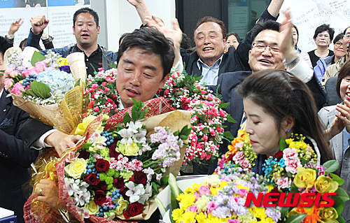 【아산=뉴시스】이종익 기자 = 20대 총선에서 국회의원 1석이 증가한 충남 아산시을 선거구의 더불어민주당 강훈식 후보가 13일 오후 충남 아산시 일원 선거사무실에서 당선이 유력시되자 부인과 함께 지지자들로부터 꽃다발을 받고 기뻐하고 있다. 2016.4.14. (사진=강훈식 당선인 제공)&nbsp; photo@newsis.com