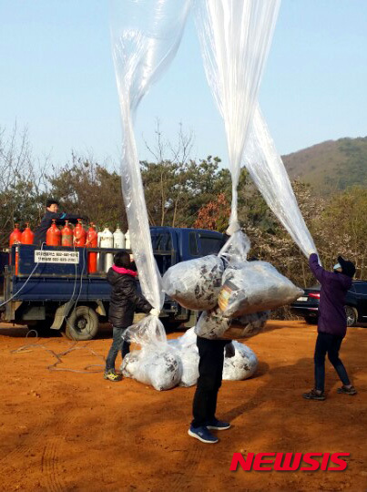 【서울=뉴시스】이영환 기자 = 박상학 자유북한운동연합 대표와 관계자들이 15일 오전 7시께 경기도 김포에서 대북전단을 북으로 살포하고 있다.&nbsp; 자유북한운동연합은 '김일성은 민족의 태양이 아니라 민족 살육자이며 반역자다', '태양절은 위선과 허구다'라는 내용의 대북전단 30만장과, 1달러 지폐 2000장, USB, DVD 1000개등을 살포했다고 전했다. 2016.04.15. (사진=자유북한운동연합 제공)&nbsp; photo@newsis.com