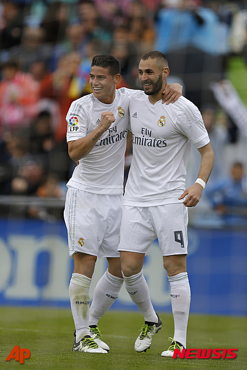 Real Madrid's Karim Benzema, right, celebrates with teammate James Rodriguez after scoring the opening goal against Getafe during a Spanish La Liga soccer match between Real Madrid and Getafe at the Alfonso Perez stadium in Getafe, near Madrid, Saturday, April 16, 2016. Rodriguez scored twice and Benzema once in Real Madrid 5-1 victory. (AP Photo/Francisco Seco)