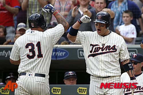 Minnesota Twins' Byung Ho Park, right, congratulates teammate Oswaldo Arcia (31) after Arcia's solo home run off Los Angeles Angels relief pitcher Joe Smith during the eighth inning of a baseball game in Minneapolis, Saturday, April 16, 2016. The Twins won 6-4. (AP Photo/Ann Heisenfelt)