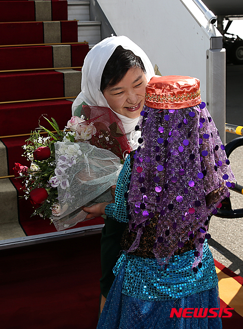 【테헤란(이란)=뉴시스】박주성 기자 = 2박 4일 일정으로 이란을 국빈 방문한 박근혜 대통령이 1일 오후(현지시간) 이란식 히잡 ‘루싸리’를 두르고 테헤란 메흐라바드 공항에 도착했다. 박 대통령이 이란 전통의상을 입은 화동에게 꽃다발을 받고 있다. 이란 의전 관행상 이례적인 특별 배려다. 2016.05.01. park7691@newsis.com