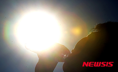 【부산=뉴시스】 하경민 기자= 전국적으로 초여름 날씨를 보인 18일 오후 부산 해운대해수욕장을 찾은 한 시민이 생수를 마시고 있다. 2016.05.18. yulnetphoto@newsis.com