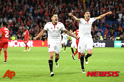 Sevilla's Vitolo, left, and Sevilla's Vicente Iborra, right, celebrates the victory during the soccer Europa League final between England's Liverpool FC and Spain's Sevilla Futbol Club at the St. Jakob-Park stadium in Basel, Switzerland, on Wednesday, May 18, 2016. (Jean-Christophe Bott/Keystone via AP) 
